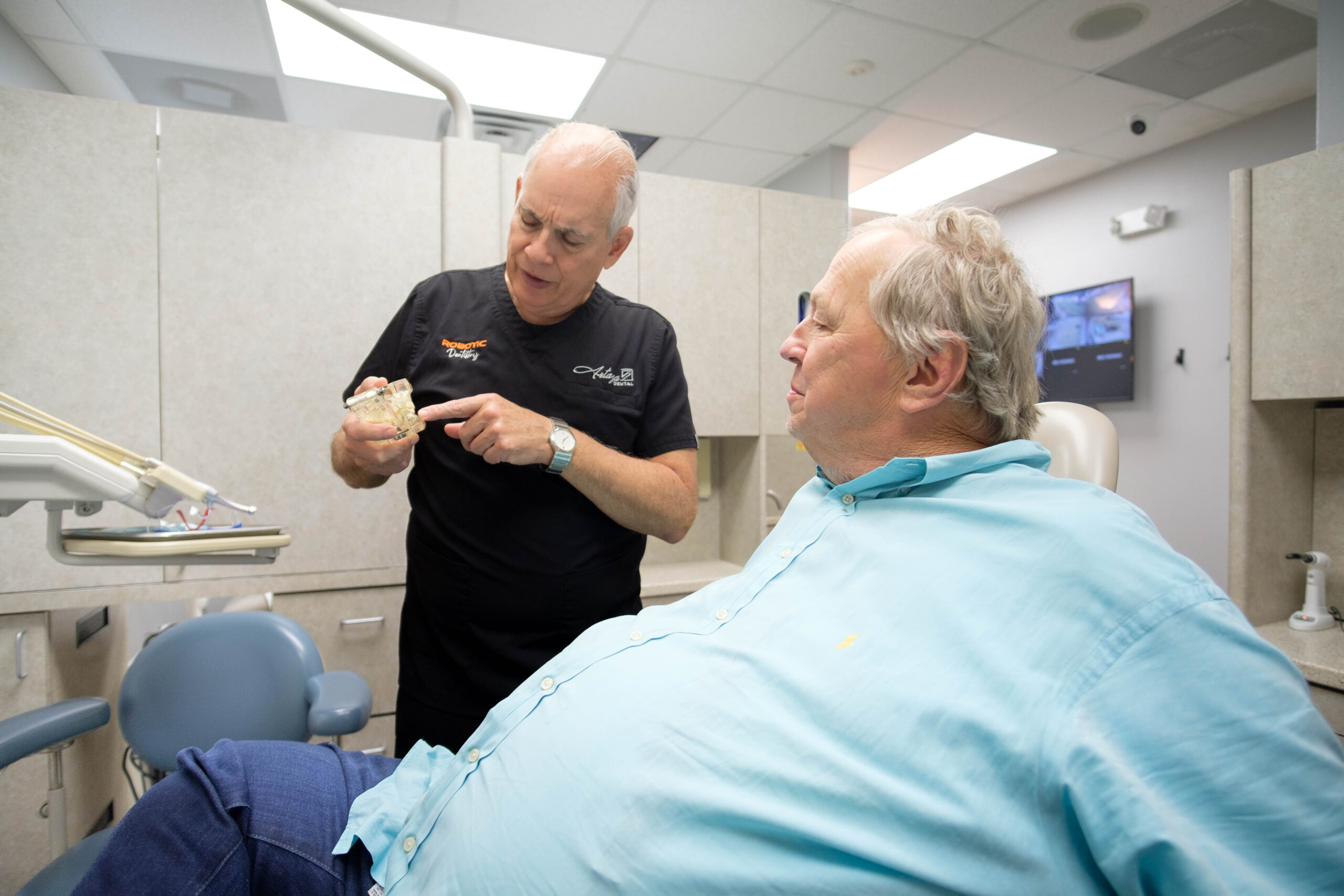 emergency dentist Houston calmly explains procedure to patient experiencing a dental emergency